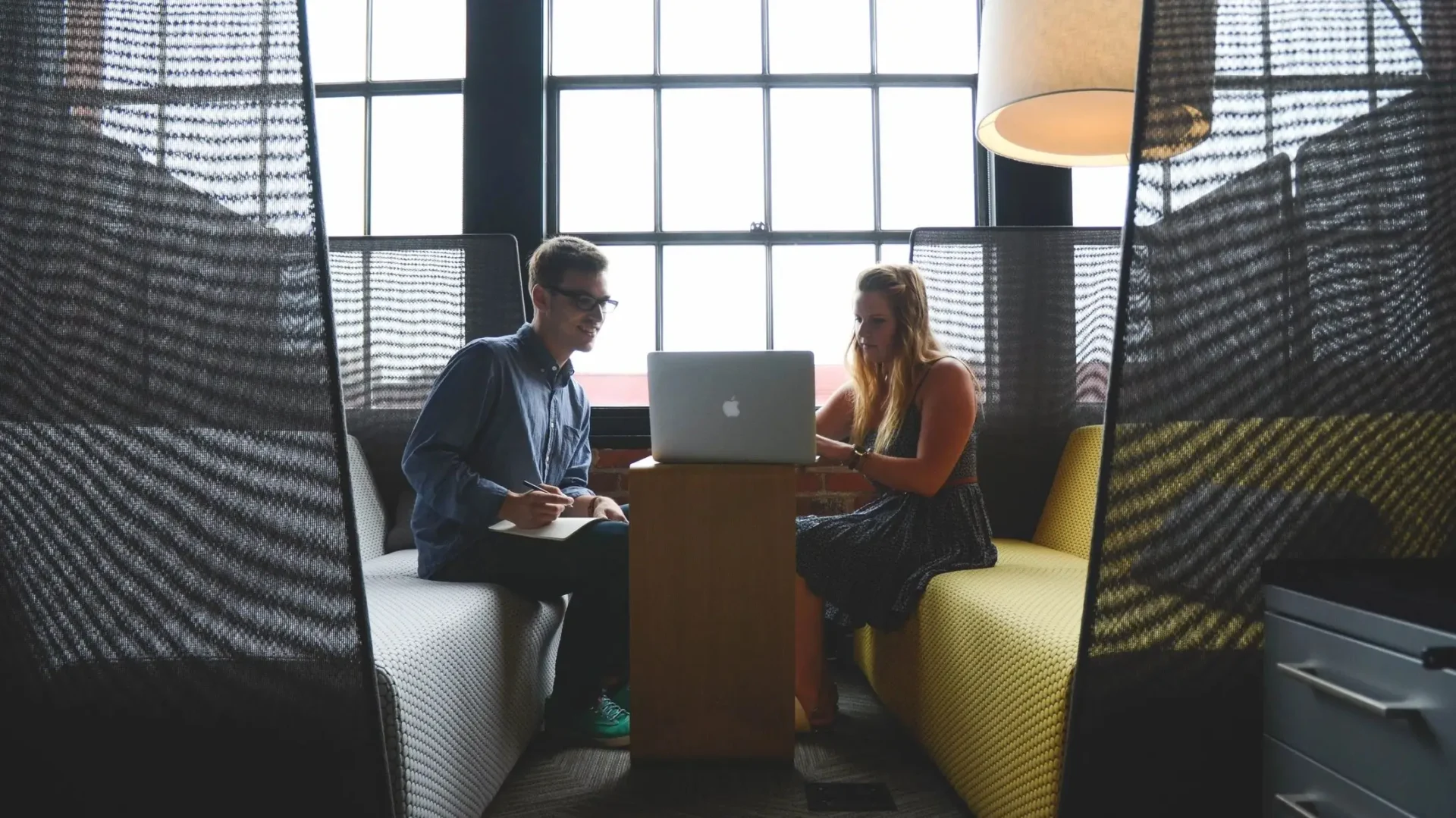 Two people sitting in front of a laptop